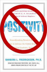 A red "banned" circle over the cover of the book entitled Positivity