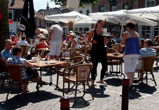 wait staff and customers on a sunny terrace in Europe