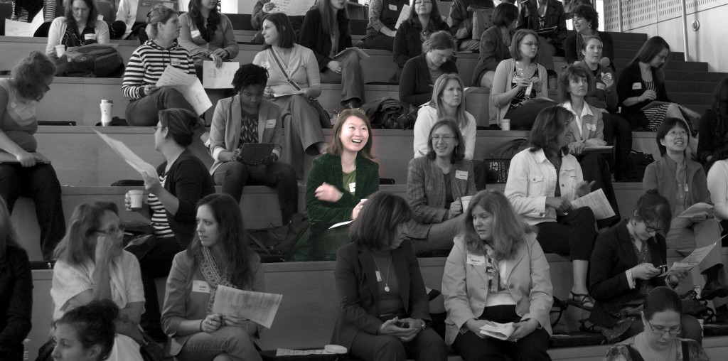 crowd of women in black and white with one in the center in color, smiling