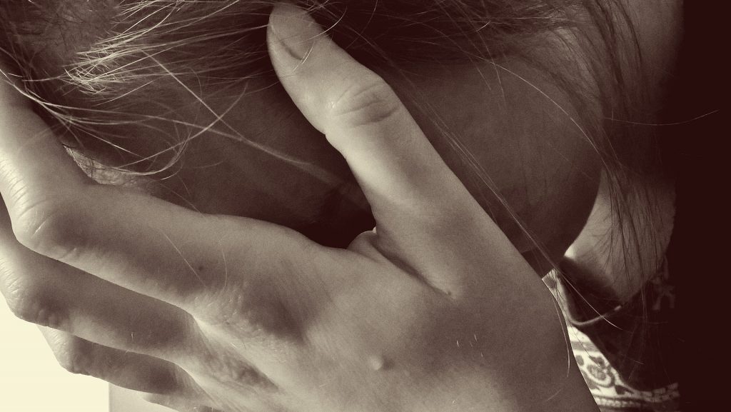 woman holding her face - close up, sepia toned